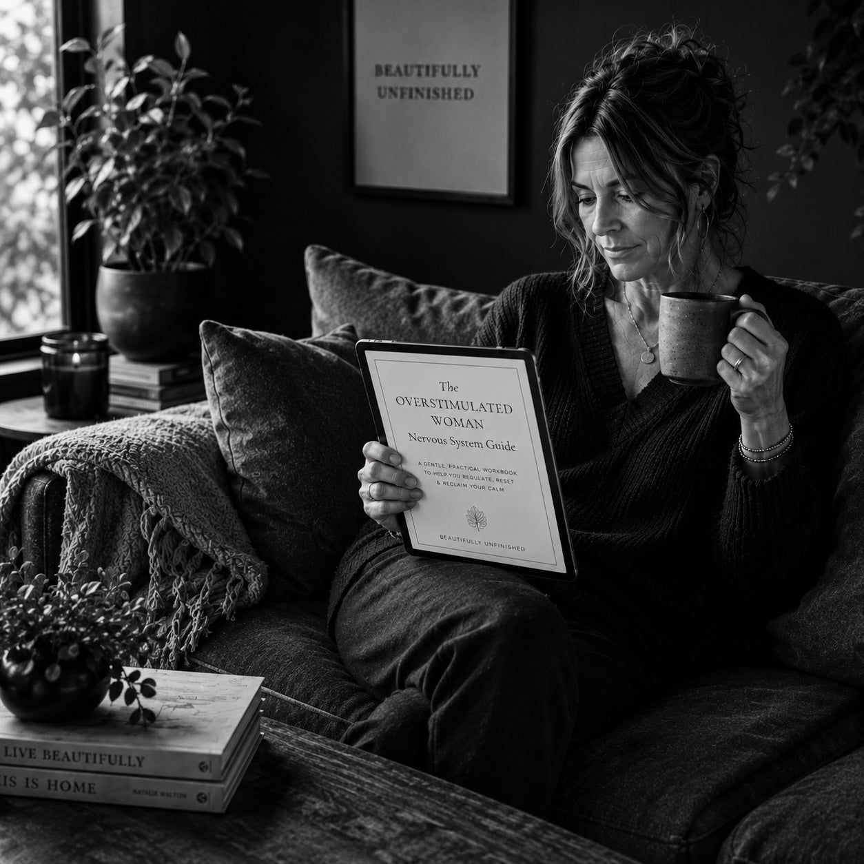 Woman reading The Overstimulated Woman sensory overload guide — black and white table scene