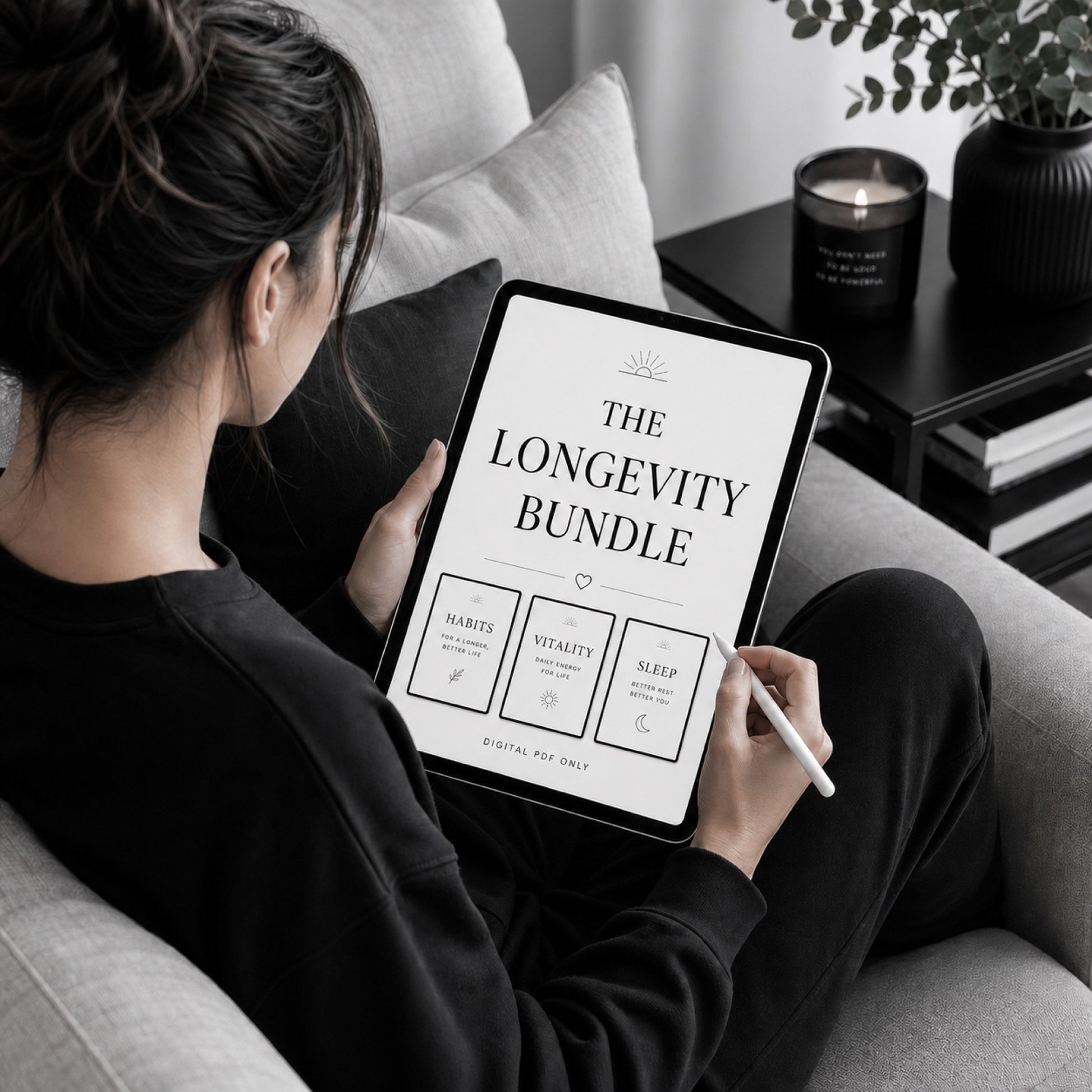 Woman reading The Longevity Bundle healthy aging workbook set — sofa lifestyle mockup