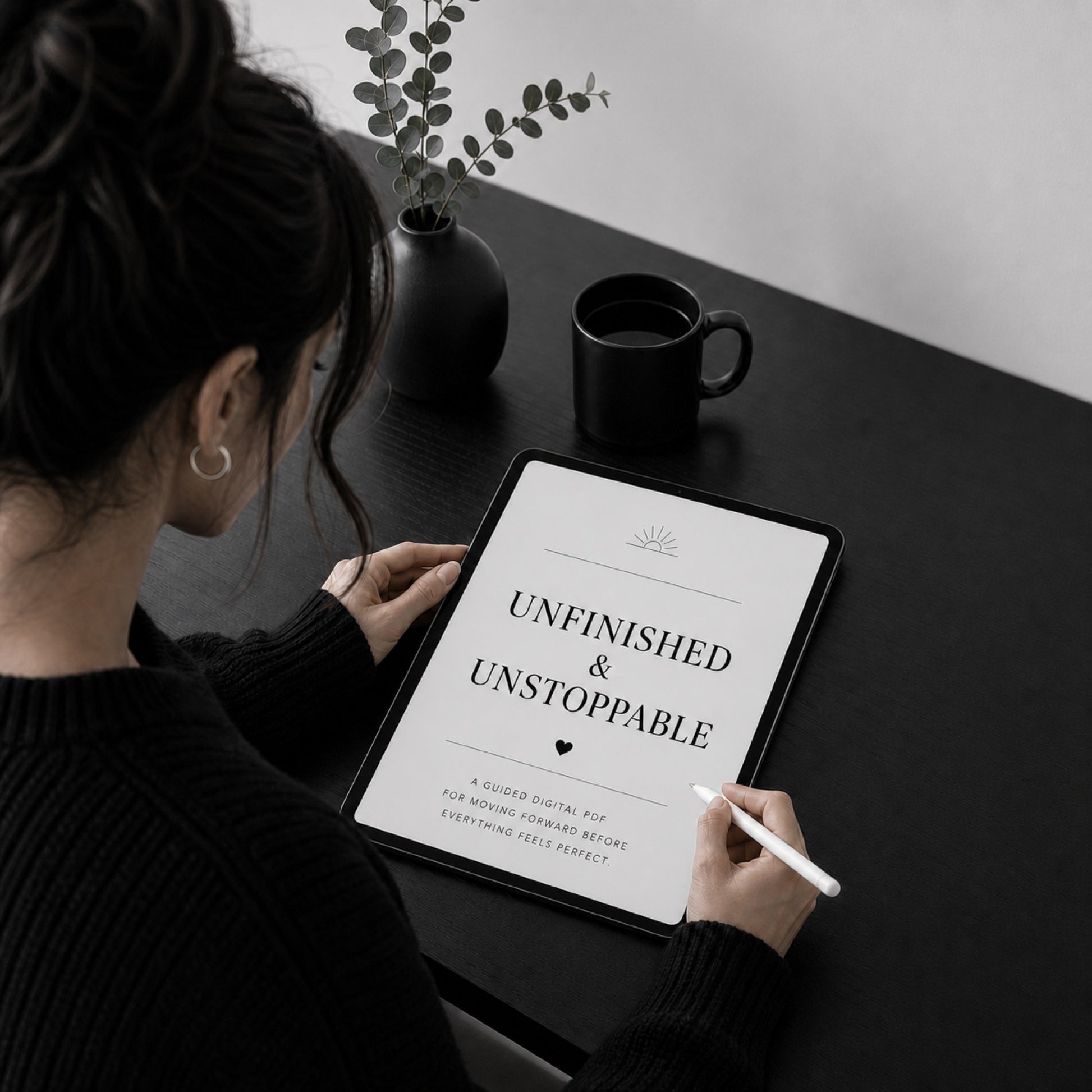 Unfinished & Unstoppable guided PDF for moving forward on a tablet — black desk scene